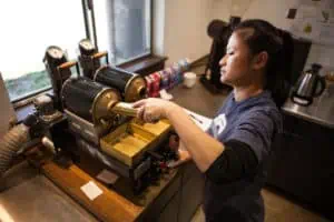 Photo of Co-owner Khanh Trang on the roaster at Greater Goods in Austin, Texas